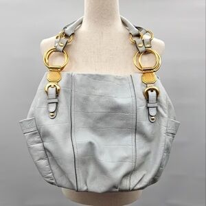 This is a B. Makowsky Corinth hobo bag in a white or icy blue color